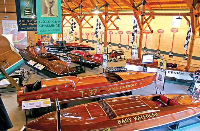 An overhead shot of the Antique Boat Museum containing many wooden boats on trailers, sparkling clean.