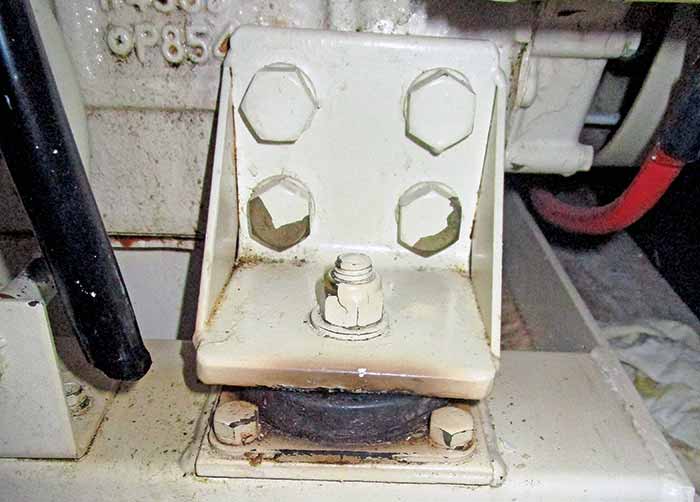 A box shaped piece of white metal with multiple screws attached is 