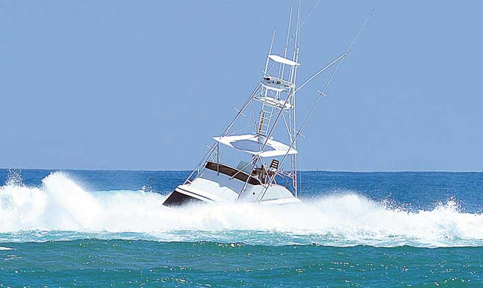 Breaking wave swamps large powerboat