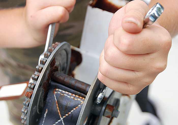 Loosen locknut holding winch strap