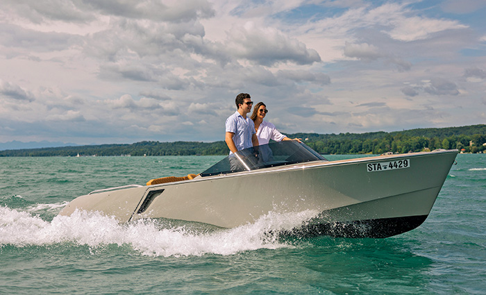 Adult male and female on a white vessel in open waters on a sunny day.