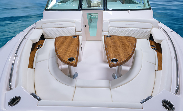 Ariel front view of a white vessel with white horseshoe seating area and two wooden tables with cup holders.
