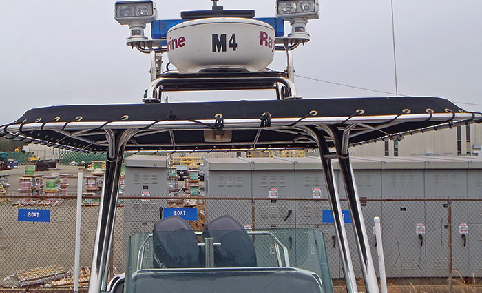 Two sets of large spotlights fixed to the top of a boat turned off during daylight.