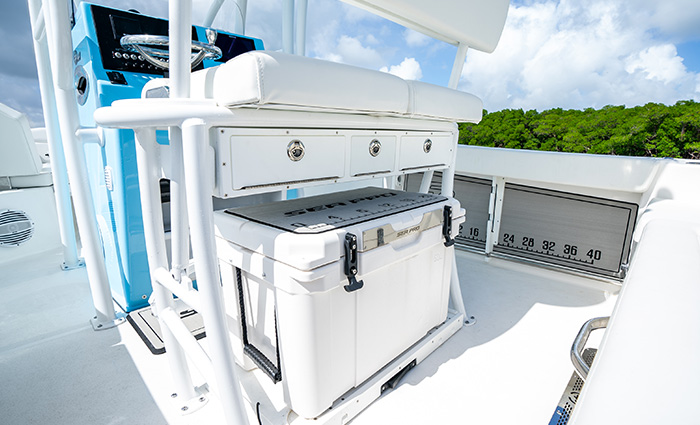 All white storage, rod holders and cooler boxes on the deck of a vessel.