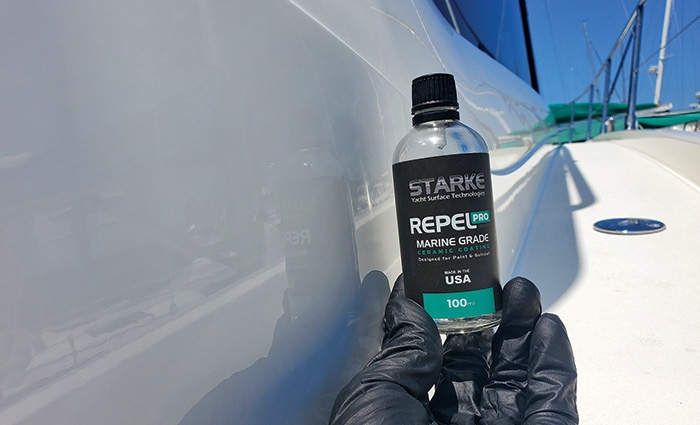 Bottle of Starke ceramic coatings held next to the side of a white boat.