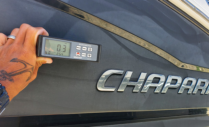 Glossmeter held next to a black boat displaying a 0.3 reading prior to ceramic application.