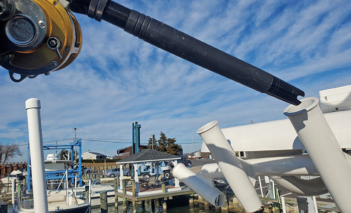 A black aluminum rod  being inserted into a white pipe.