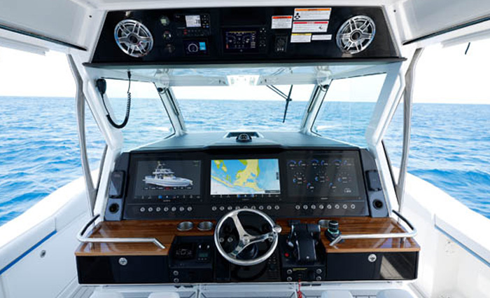 Point of view of a vessel's steering and navigation console while out on blue waters. 