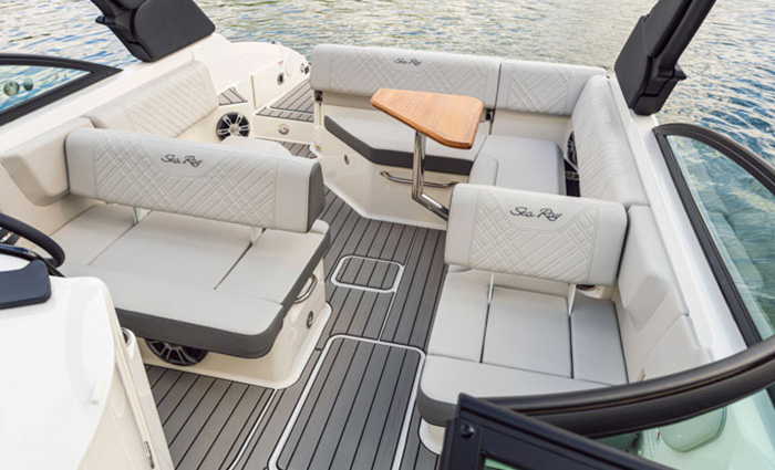 White leather seating area featuring a small wooden table on a Sea Ray vessel.