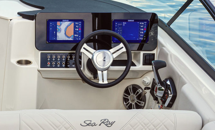 Steering and navigation on a white Sea Ray vessel.