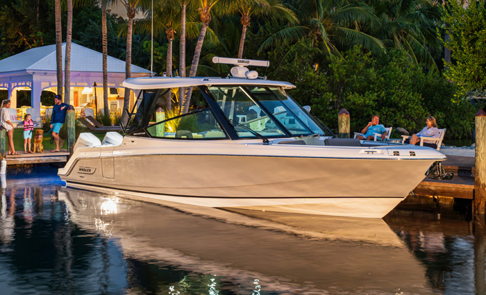 White vessel with tan trim on the water at sunset.