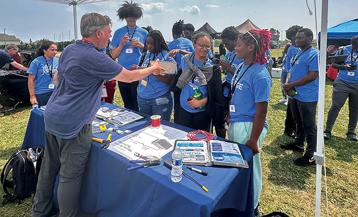 Group of young adults getting swag from a outdoor event.