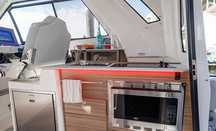Vessel interior showcasing stainless sink, refrigerator, oven and stovetop.