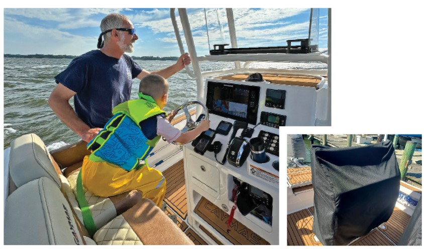 Gray hair and gray bearded adult male standing beside a middle-aged boy steering a vessel on open waters during a sunny day.