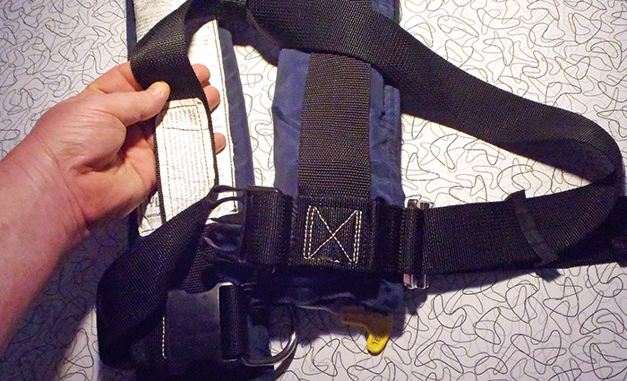 Adult hand holding a navy and black strap.