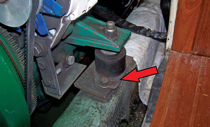A red arrow pointing to an area of a clean black engine mount that has moved.