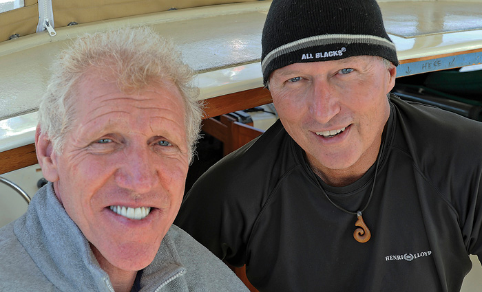Two senior adult males posing for a photo inside the cabin of a boat.